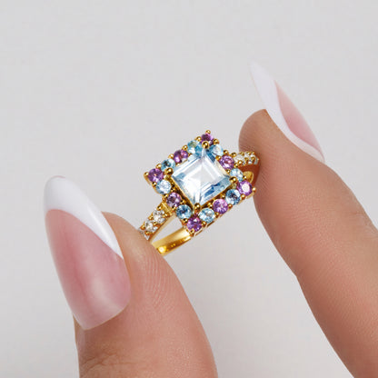 Amethyst & blue topaz gemstone square cocktail ring  held by model