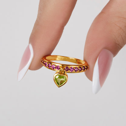 Rhodolite & peridot heart gemstone charm ring held by model